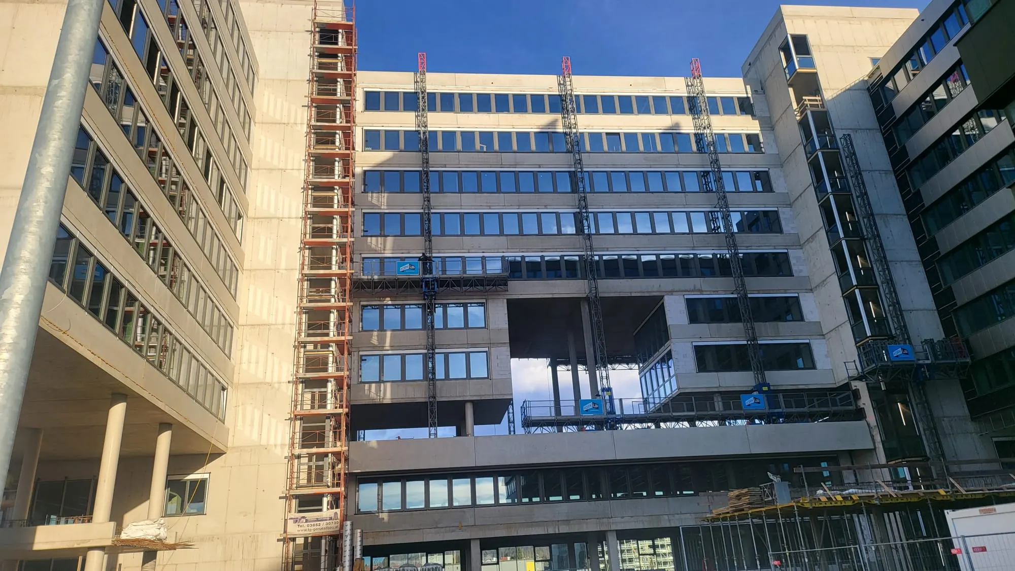 Fassade mit durchlaufenden Fensterbändern zwischen zwei Gebäudeflügeln